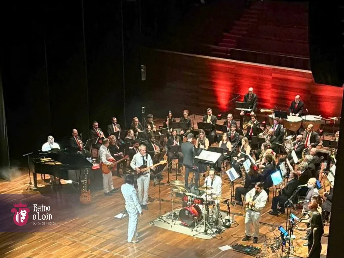 Vista frontal de toda la Banda Reino de León durante un concierto formal en un teatro
