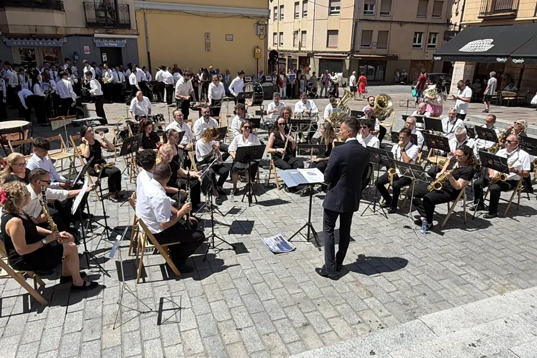 El director y los músicos de la Banda actuando en una plaza al aire libre