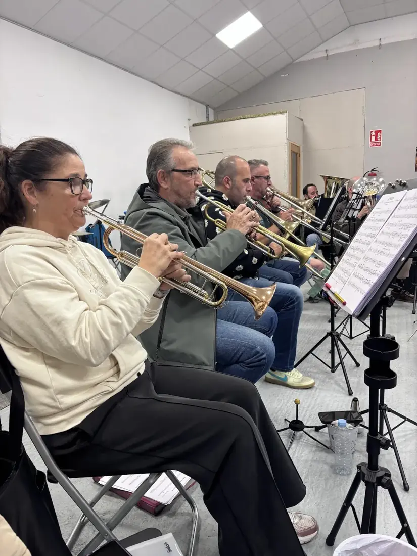 Músicos de viento de la Banda Reino de León compartiendo un ensayo